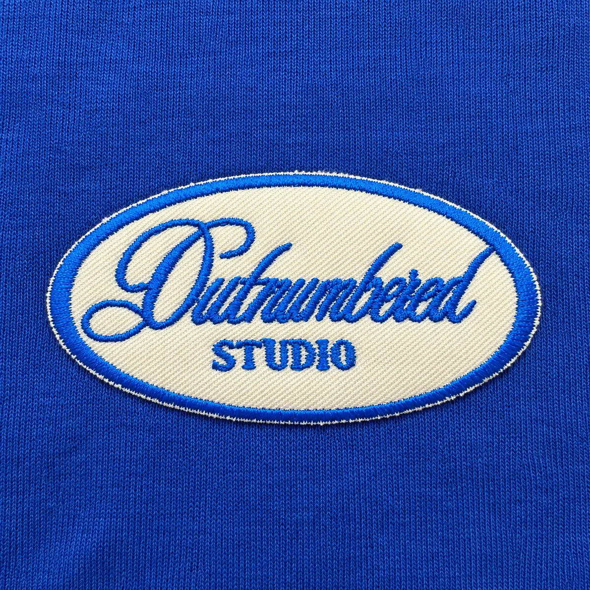 Close-up of the embroidered Outnumbered Studio patch